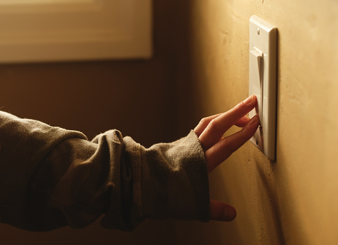 A girl operating a light switch