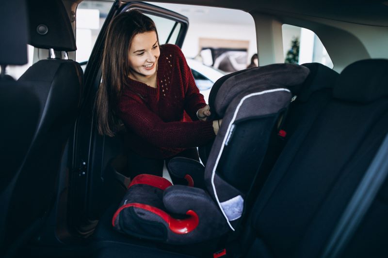 woman installing a car seat