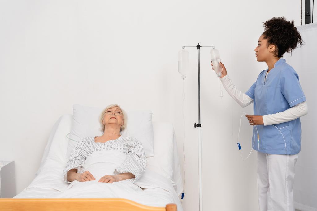 nurse holding bottle of intravenous 