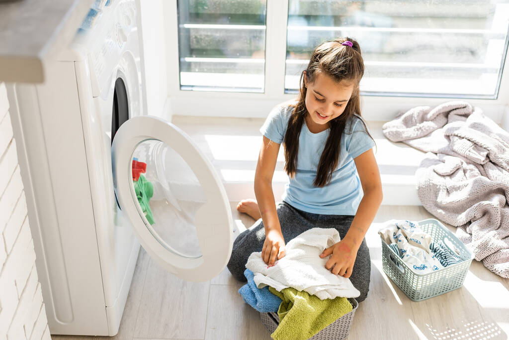 Happy little girl doing laundry