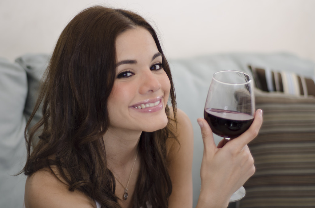 Young beautiful woman enjoying a glass of wine 