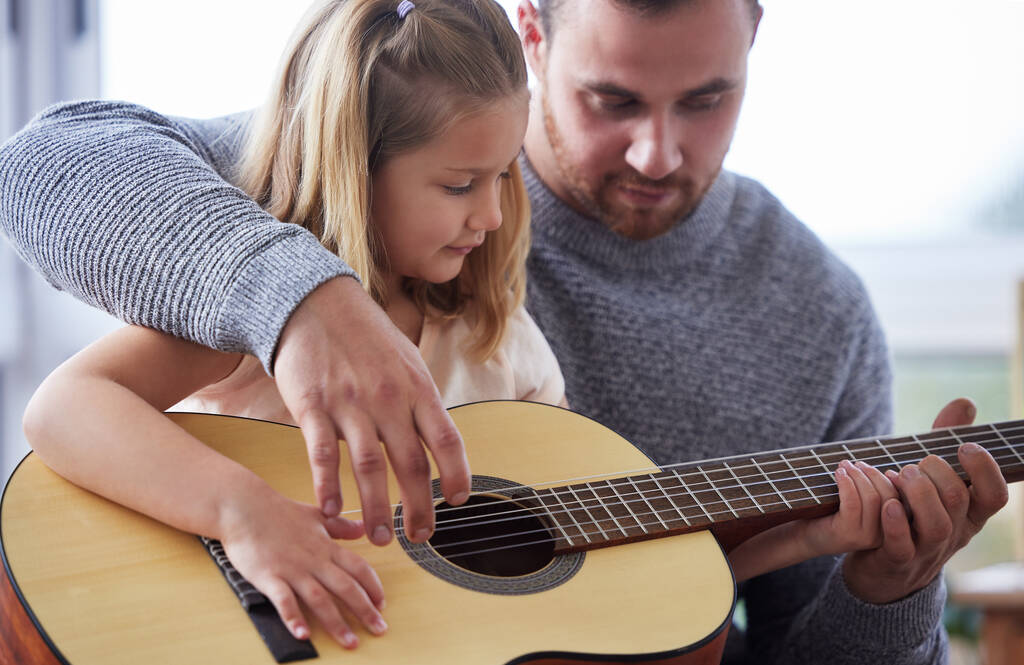 little daughter playing guitar