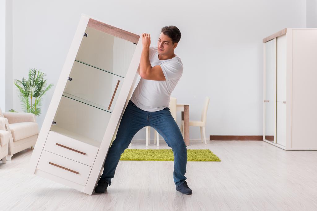 Man moving furniture at home