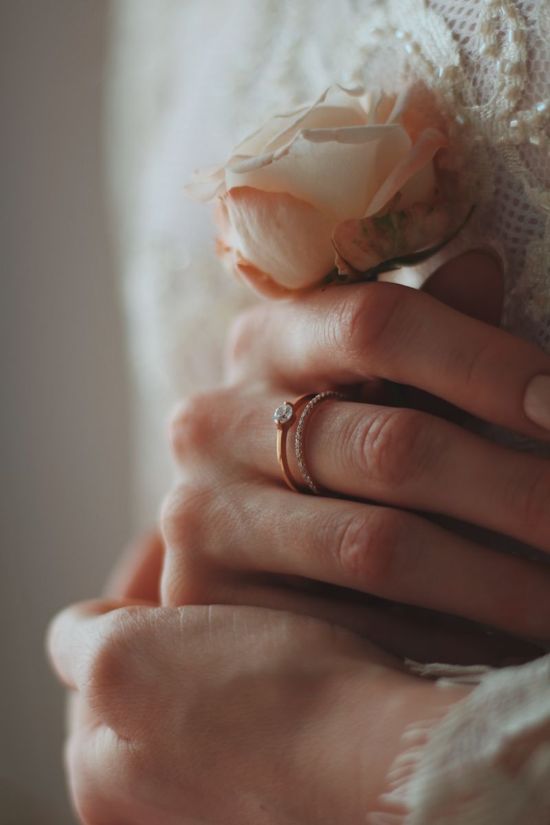 closeup shot bride wearing beautiful diamond ring holding rose What Is a Custom Engagement Ring?