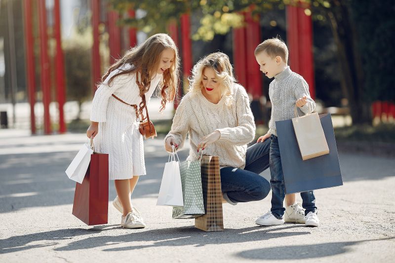 mother with child with shopping bag city Back to School Clothes Shopping Guide: What Kids Really Need