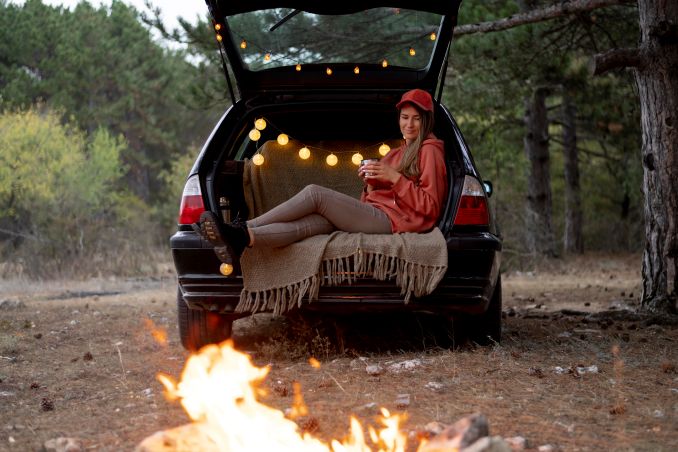 young woman enjoying bonfire Essential Car Camping Gear