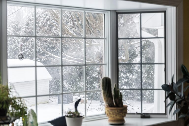 Drafty winter window with frost and cold air entering a warm home