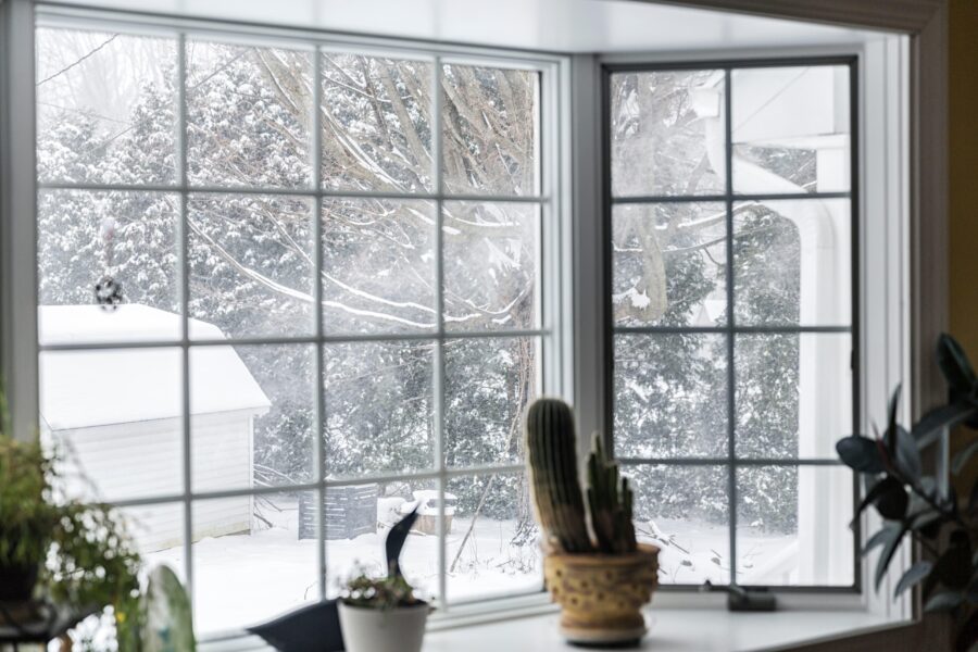 Drafty winter window with frost and cold air entering a warm home